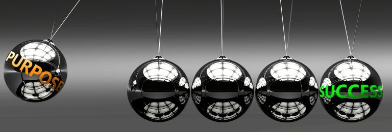 Four shiny silver balls hanging from a string.